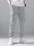 Manfinity Hypemode Loose Fit Men's Slogan Graphic Cargo Pants With Grommet Detail, Flap Pockets, And Drawstring Closure - MapleCo